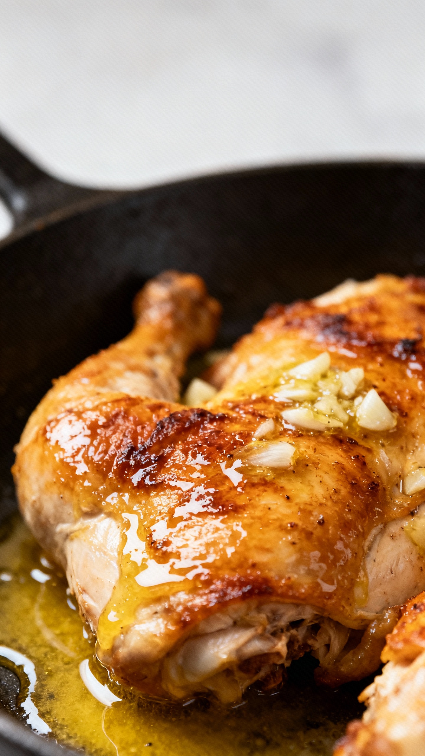 close-up juicy chicken in skillet, garlic butter gloss