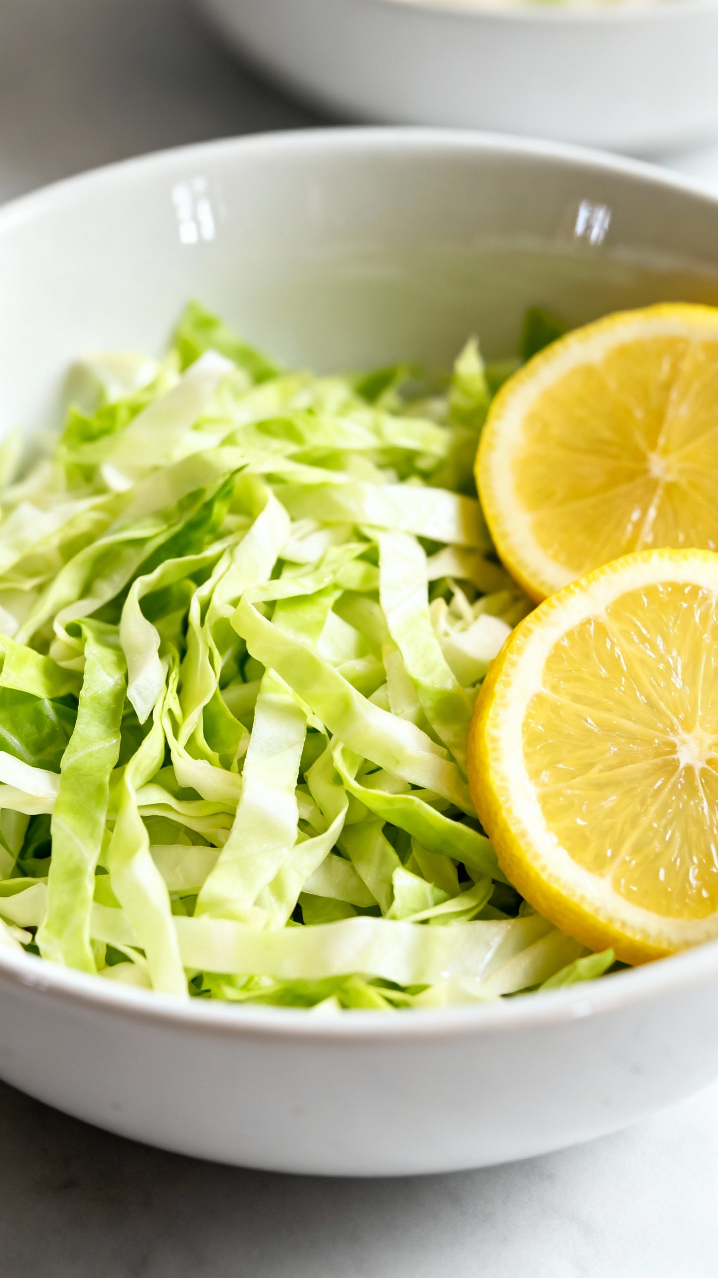 cabbage salad with lemon wedges on white ceramic bowl