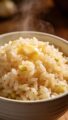 buttery garlic rice in white bowl, steam rising