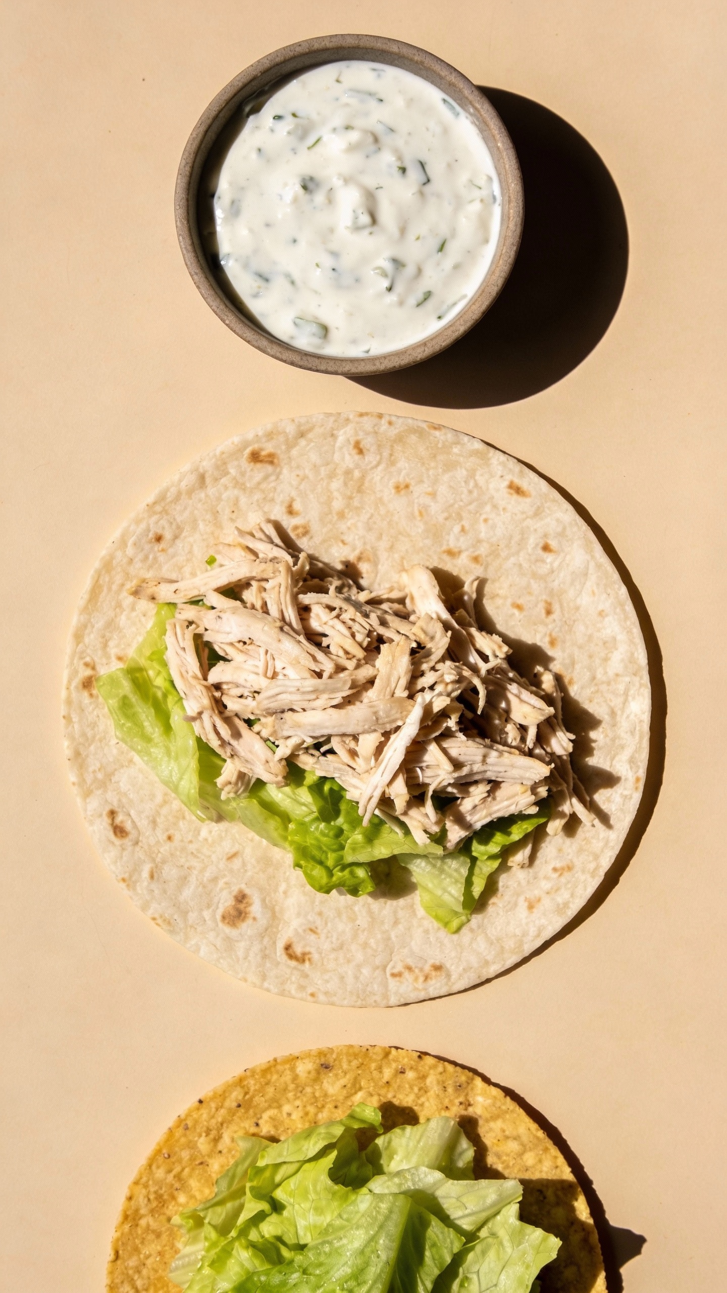 Ingredients flat lay: tortilla, shredded chicken, ranch, tostada, lettuce