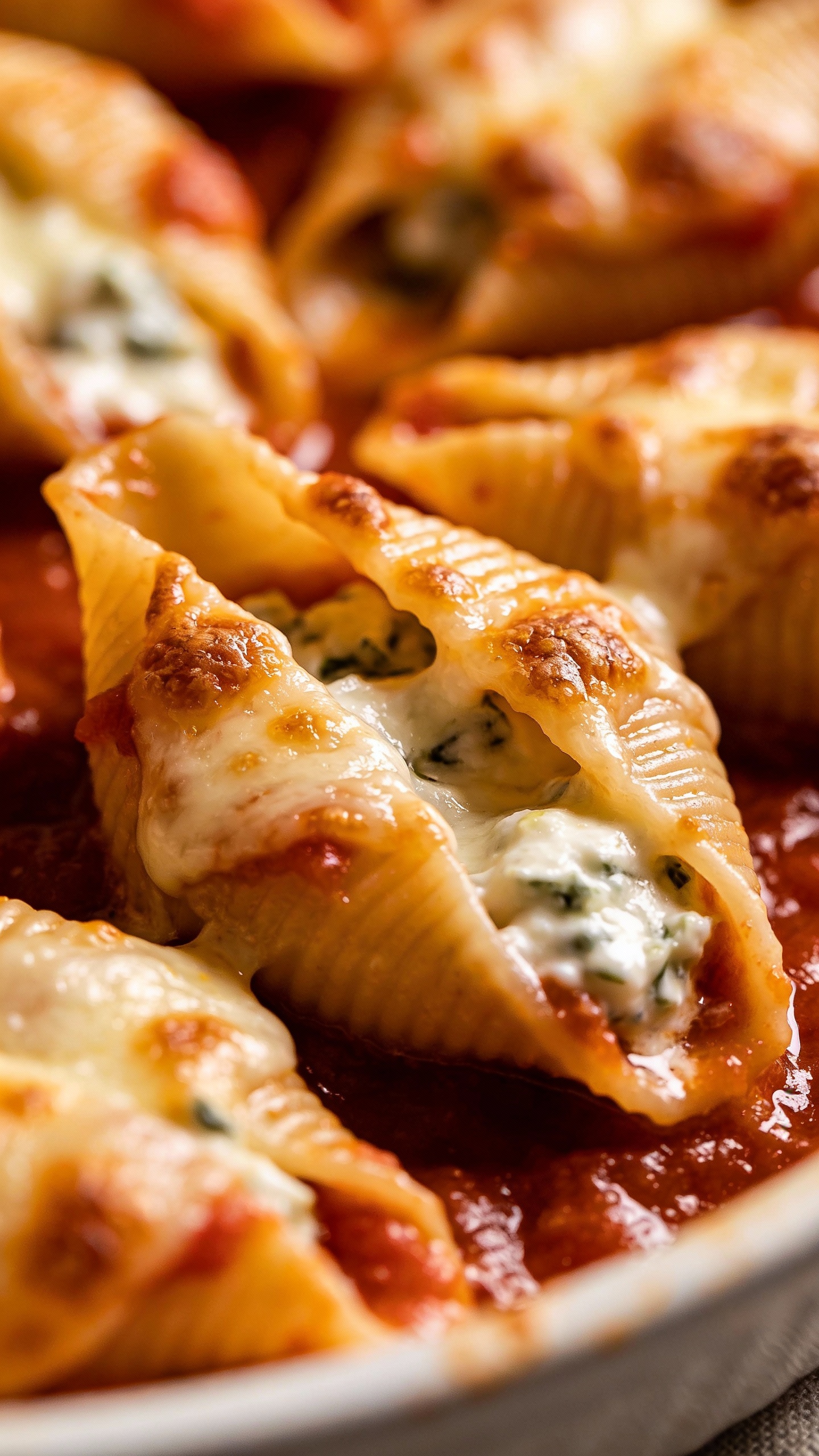 baked ricotta stuffed shells in marinara, bubbling cheese