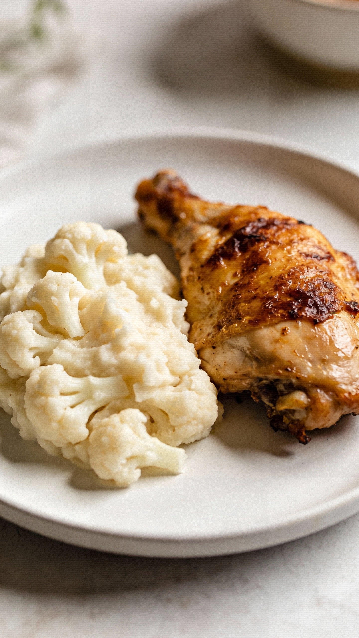 mashed cauliflower with roasted chicken, minimalist plate, natural light