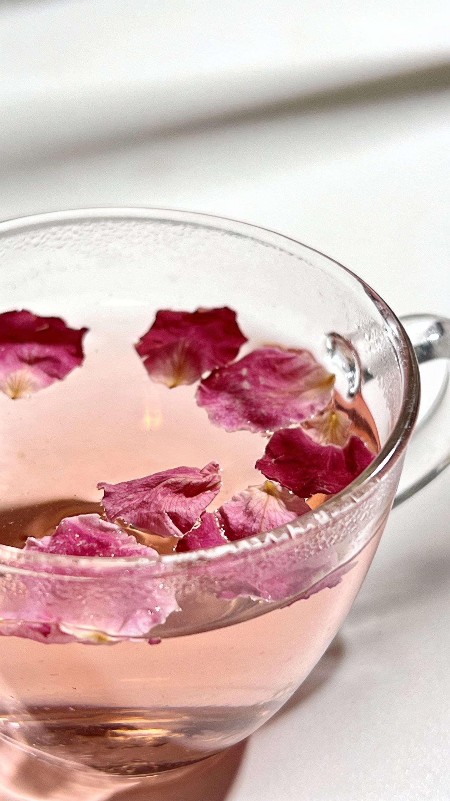 rose petal tea in clear glass cup, white background