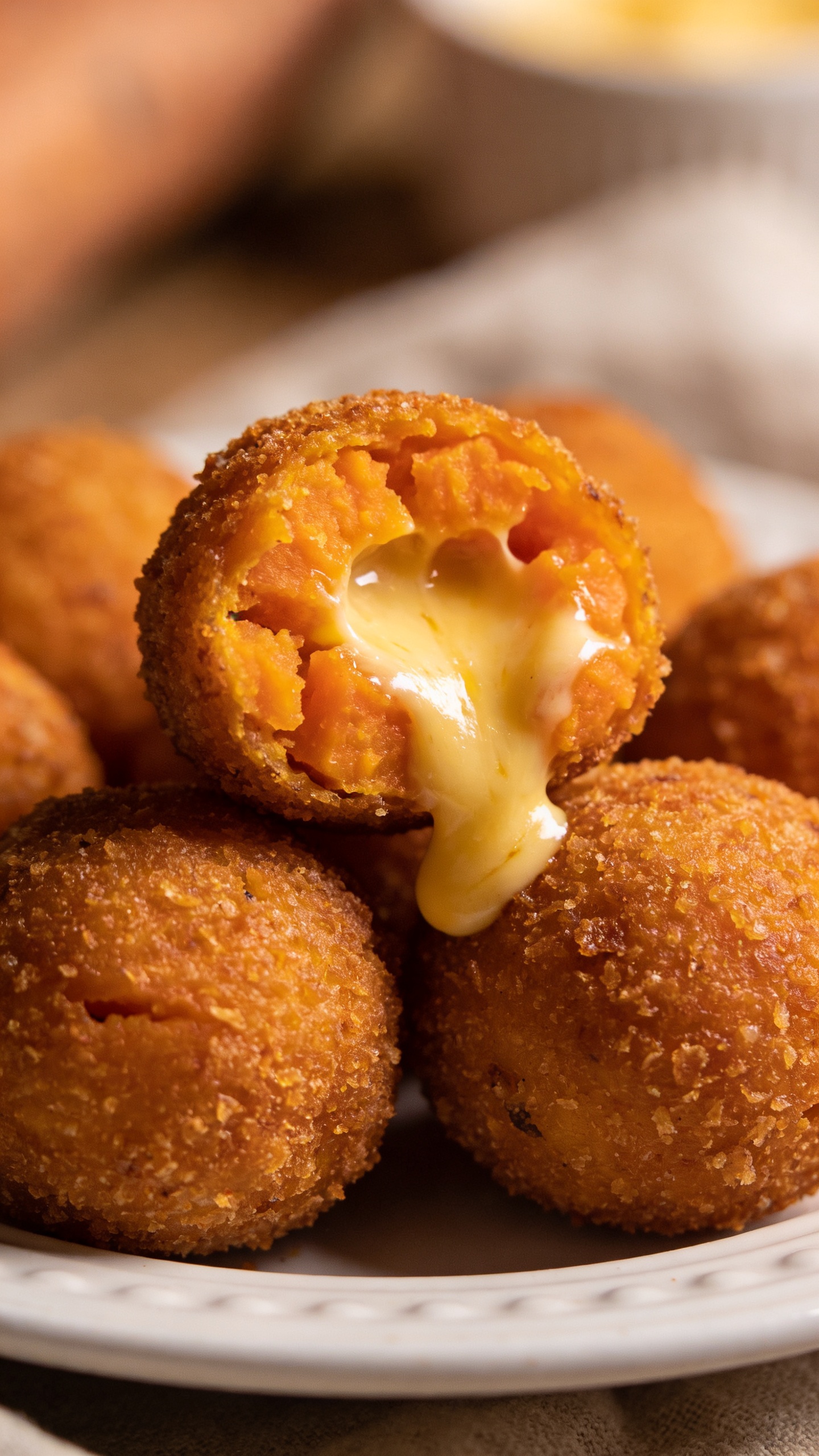 gooey cheese-stuffed sweet potato croquettes on white plate