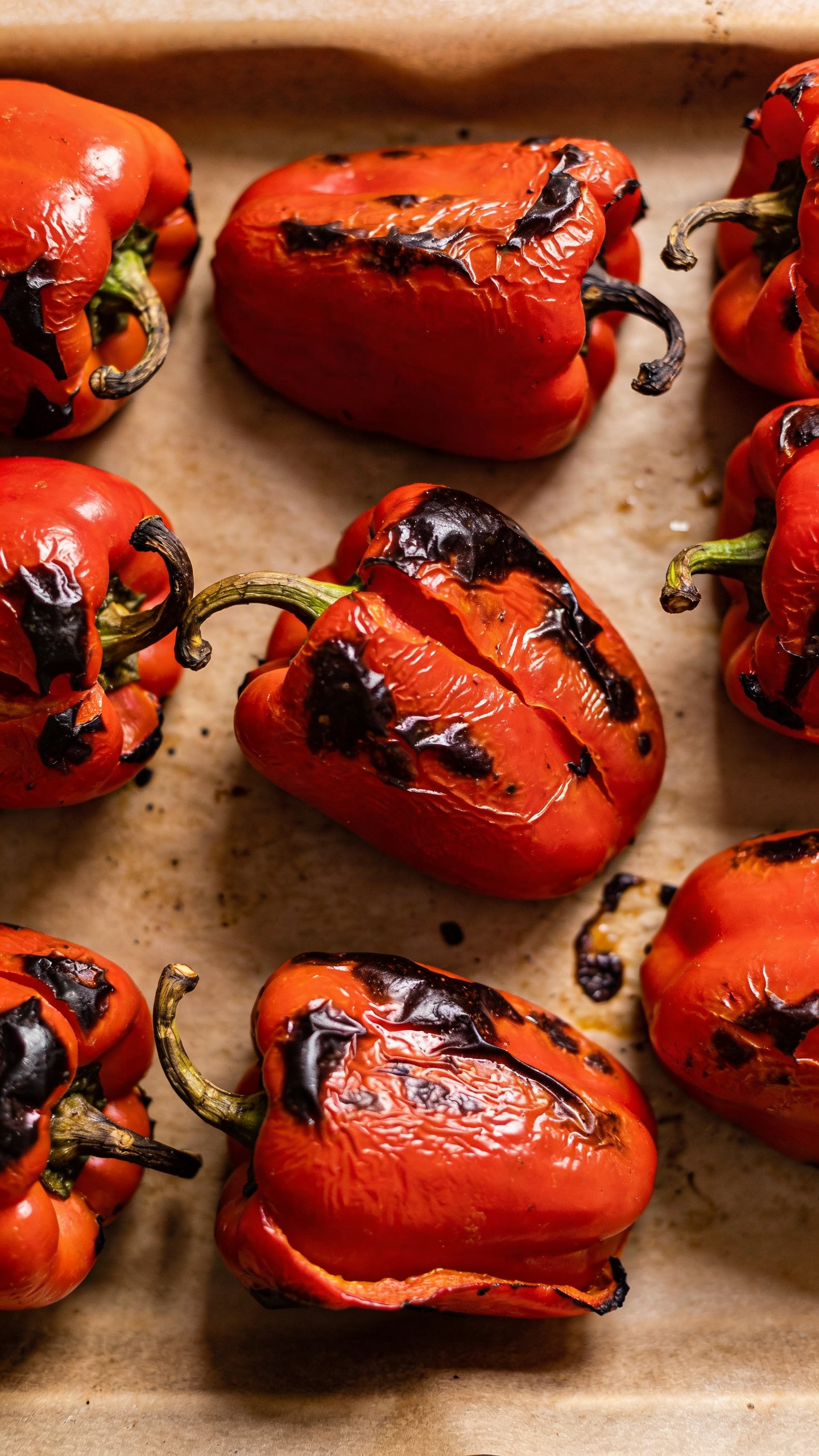 charred red bell peppers on sheet pan, overhead
