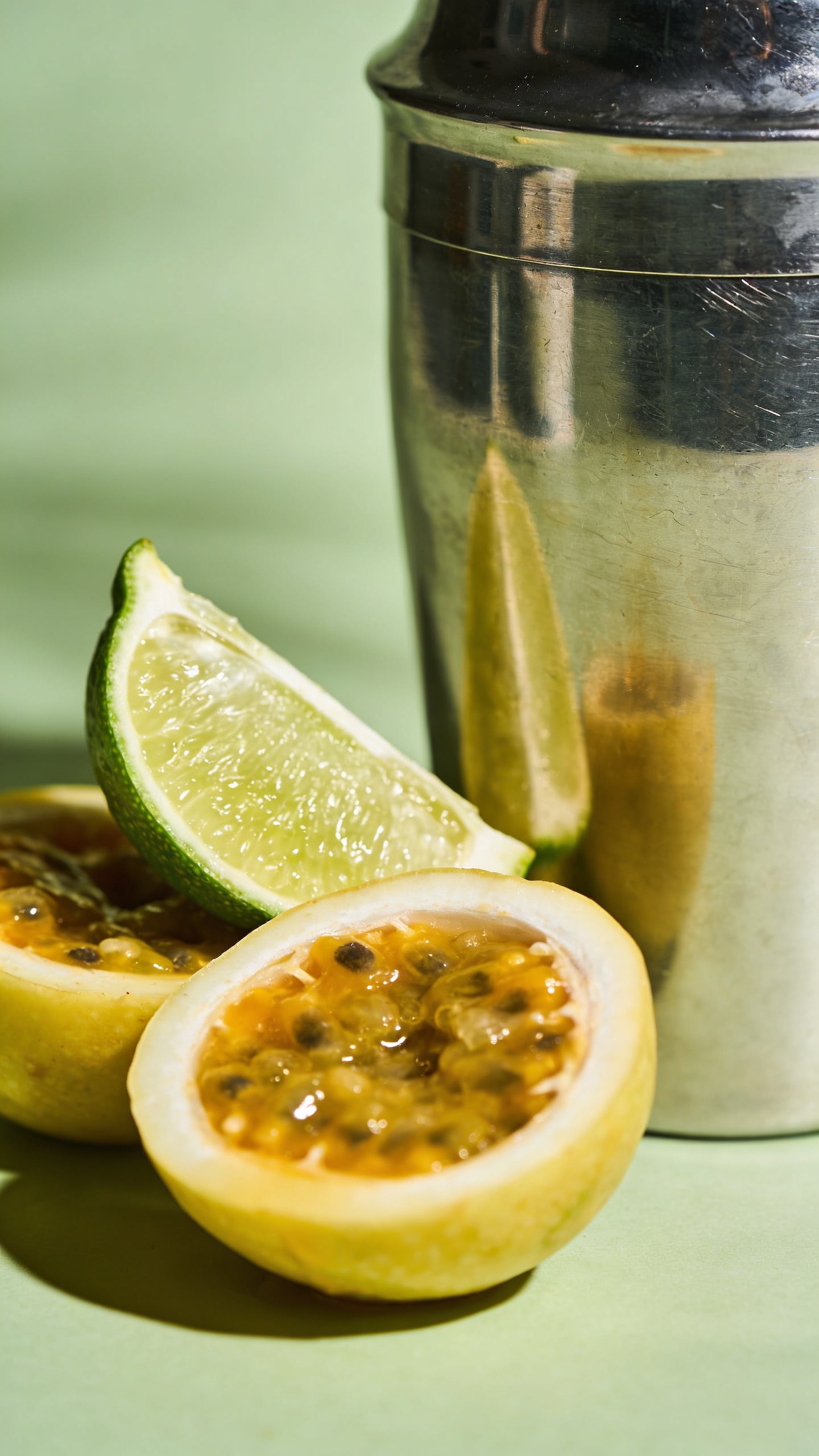 lime wedges and passion fruit beside cocktail shaker